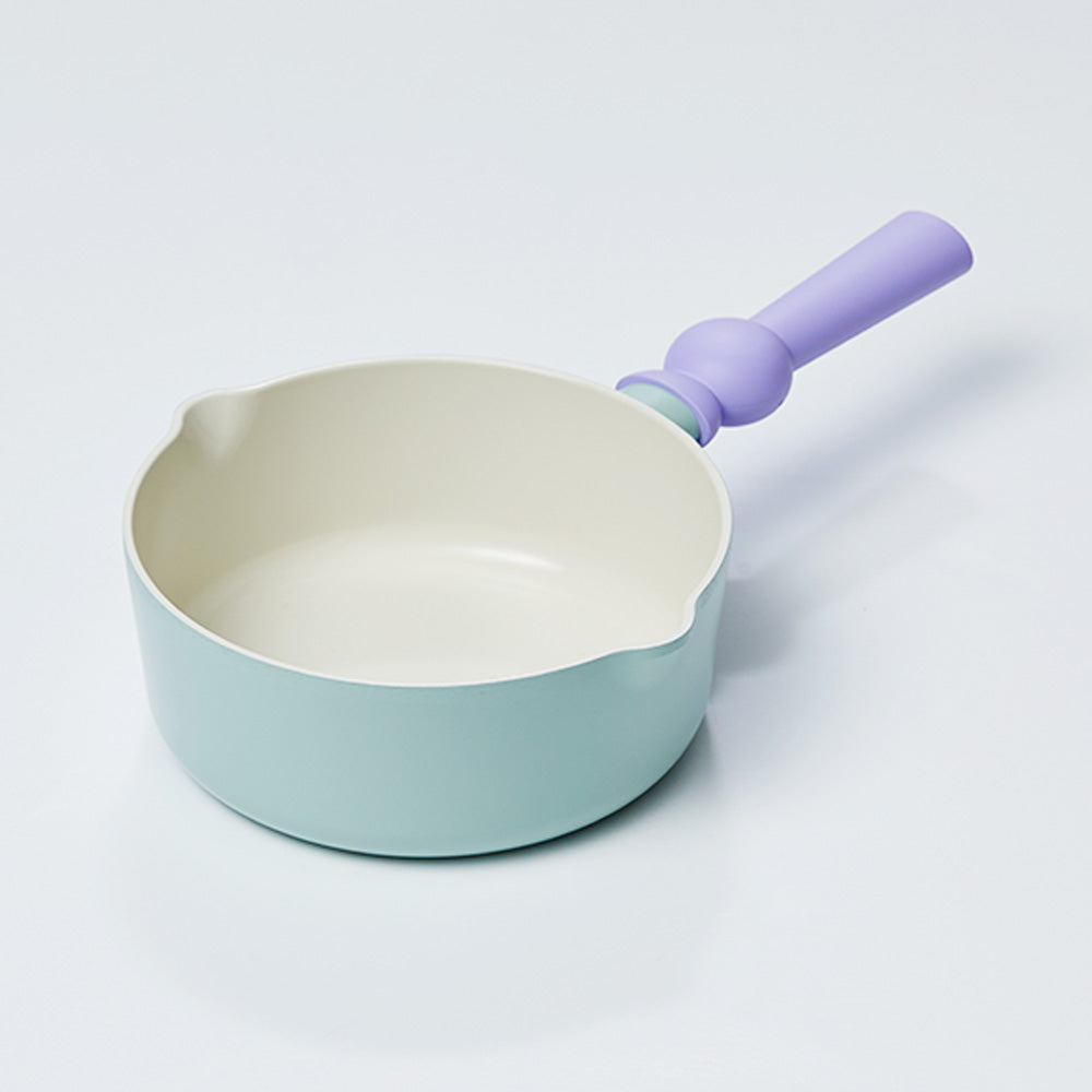 A petite pastel-colored wok with a light green body and a purple handle, displayed on a white background