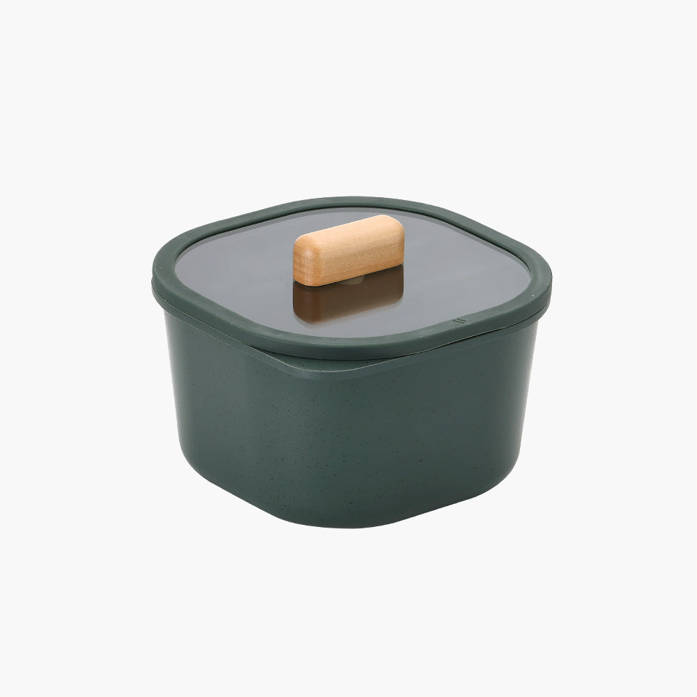 Square green food storage container with a glass lid and wooden handle.